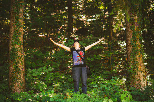 istock Young woman enjoying nature in green forest 1299459671