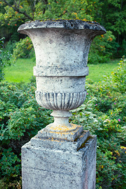 istock old antique vase outside in green park, landscape view 1299461084