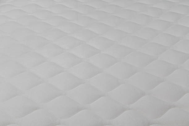 istock Soft white mattress close-up background with selective focus. 1299461103