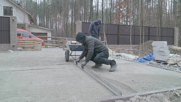 A driveway featuring stamped concrete, leading to a garage and a porch, showcasing a modern residential design.