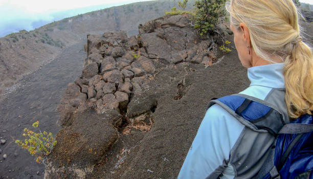 istock Woman hikes along volcanic rim 1299463807