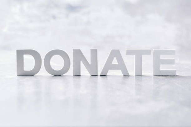 istock Word DONATE made with cement letters on grey marble background. Copy space. Biblical, spiritual or christian reminder 1299466790