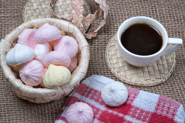 baisers faits maison de meringue et tasse de café. biscuits de meringue dans le panier d’osier sur le fond normal de sackcloth - coffee sack photos et images de collection