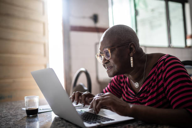istock Senior woman using laptop at home 1299469100