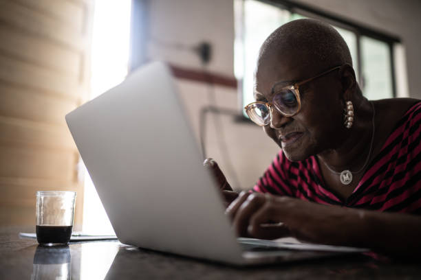 istock Senior woman using laptop at home 1299469414