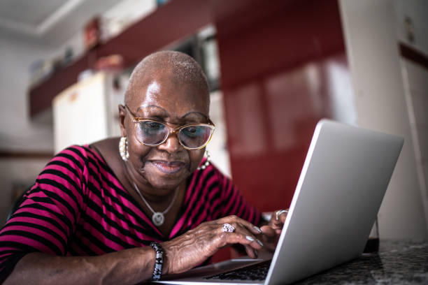 istock Senior woman using laptop at home 1299469534