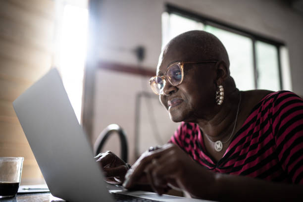 istock Senior woman using laptop at home 1299469606