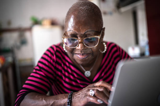 istock Senior woman using laptop at home 1299469657