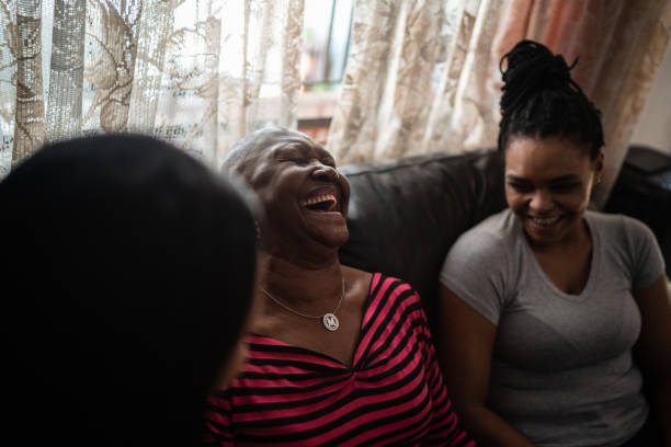 istock Mother and daughters relaxing and talking at home 1299469701