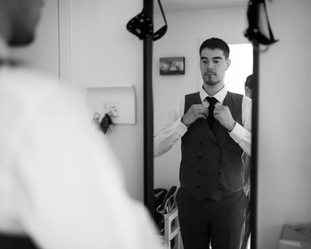 istock Reflection in the mirror of Young Man adjusting his tie 1299470650