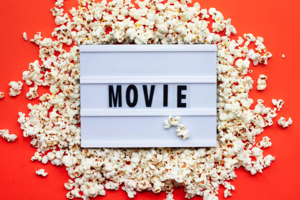 istock Popcorn, lightbox text Movie time on red paper background. Top view Template 1299471361