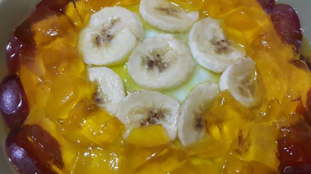 Creamy tasty sweet custard with banana pieces layered on surface. Creamy tasty sweet custard with banana pieces layered on surface. A close up tope view of home made custard, a dairy products for dessert after meal. hollandaise sauce stock pictures, royalty-free photos & images