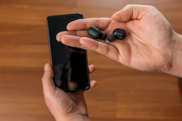 Bluetooth earbuds or earphones and charger box on hand
