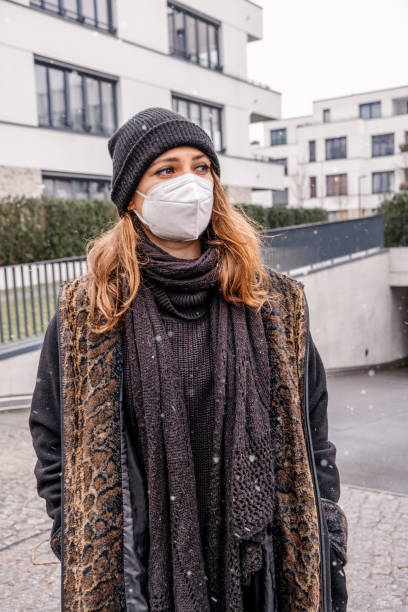 istock young brunette woman outdoors on snowy day wearing a ffps mask 1299474174