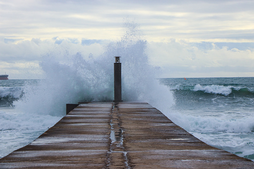 Big ocean wave hit in a jetty in a stormy day