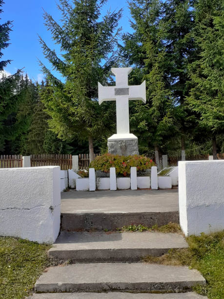 istock Memorial cross white surrounded by coniferous trees. 1299475198