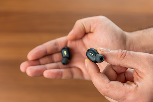 Bluetooth earbuds or earphones and on hand