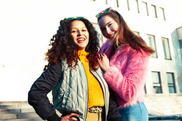 istock two pretty student girlfriends happy smiling outside at university building, caucasian and african woman, lifestyle people concept 1299476387