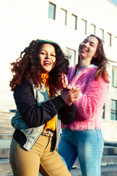 istock two pretty student girlfriends happy smiling outside at university building, caucasian and african woman, lifestyle people concept 1299476393