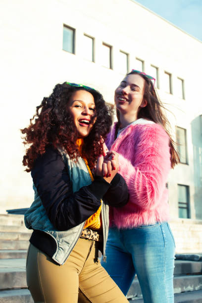 istock two pretty student girlfriends happy smiling outside at university building, caucasian and african woman, lifestyle people concept 1299476401