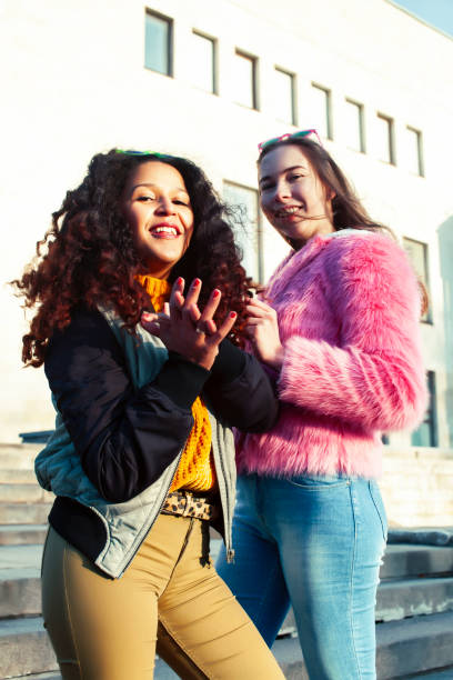 istock two pretty student girlfriends happy smiling outside at university building, caucasian and african woman, lifestyle people concept 1299476404