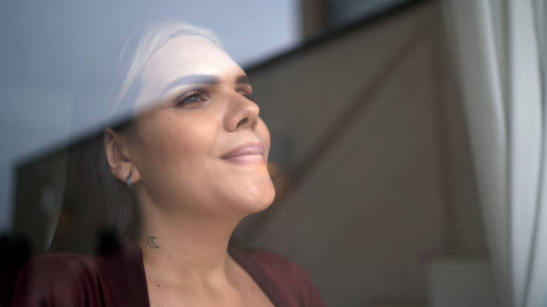Transgender woman looking through window