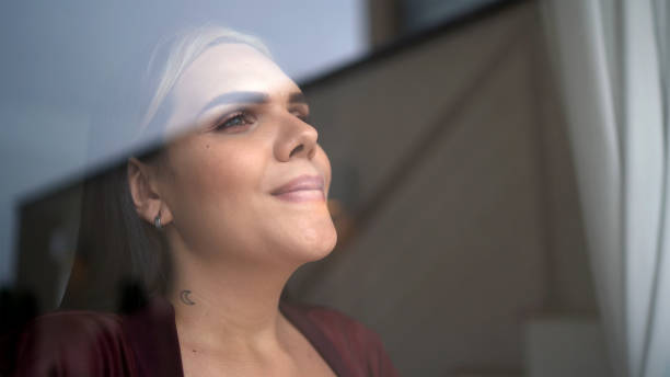 Transgender woman looking through window Transgender woman looking through window transgender person photos stock pictures, royalty-free photos & images