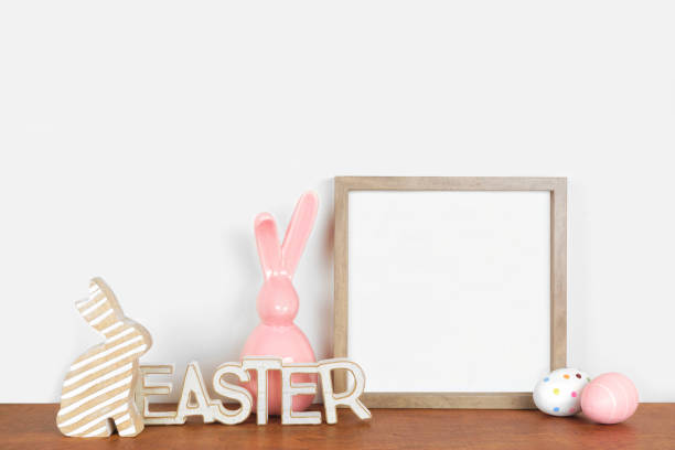 istock Mock up square wood frame with rustic Easter decorations on a wood shelf against a white wall 1299478818
