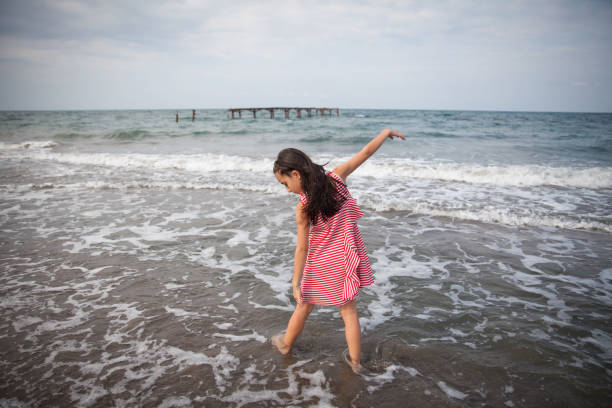 istock A girl having fun by the sea. 1299480366