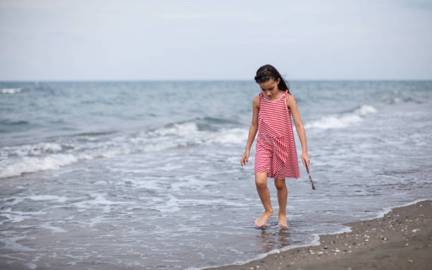 istock A girl having fun by the sea. 1299480498