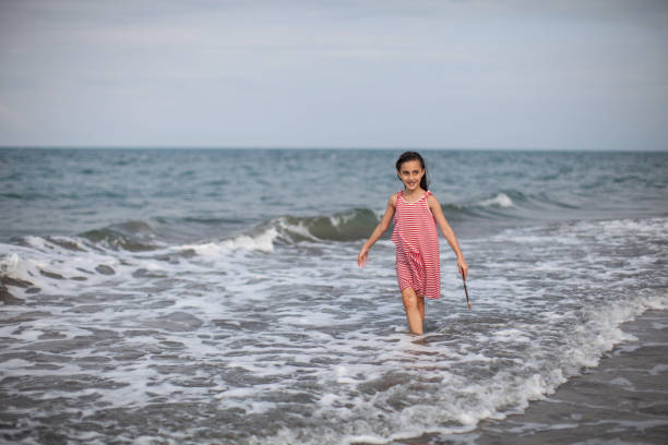 istock A girl having fun by the sea. 1299480517