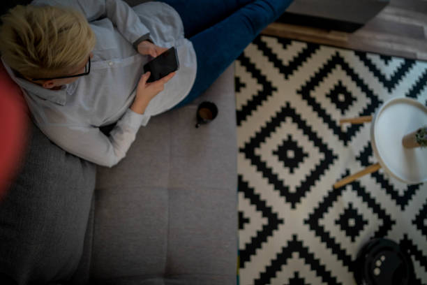 istock One woman, at home relaxing, while robot vacuum cleaner is working. 1299481488