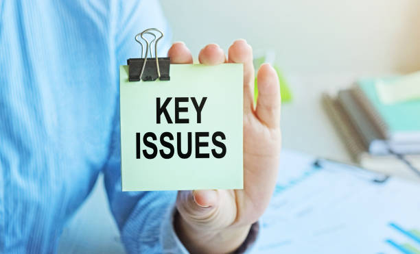 istock KEY ISSUES written on a voucher shown by a female businessman. Soft focus. 1299481524
