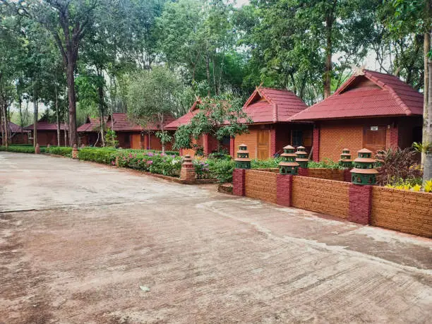 Row of cubicle or guesthouse made by red brick among abundance forest.