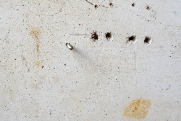 istock Drilled Holes in White Scratched Concrete Wall Room reconstruction Process with Copy Space 1299486341