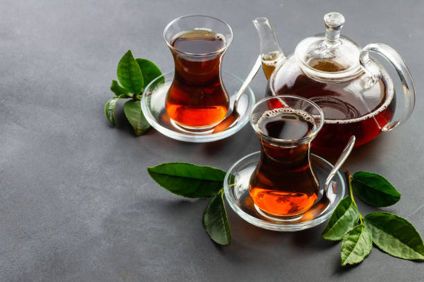 tazza di vetro di tè nero con foglie di tè fresco, tradizionale bevanda calda prodotta in turco - homewares rustic herbal tea herb foto e immagini stock