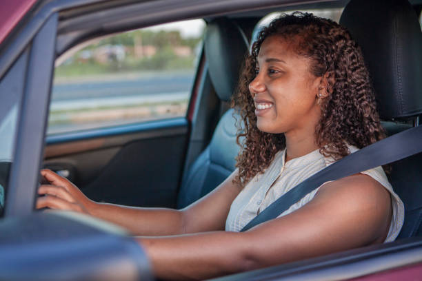 istock Black woman driving a car and smiling. 1299488121