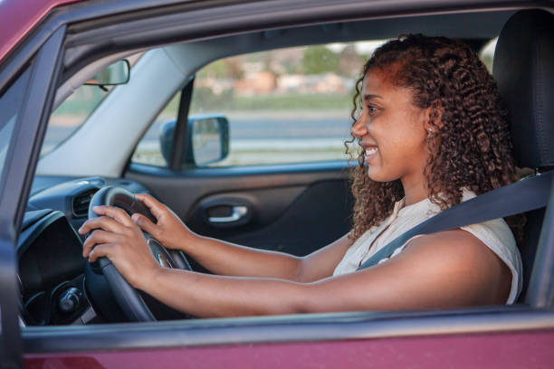 istock Black woman driving a car and smiling. 1299488133