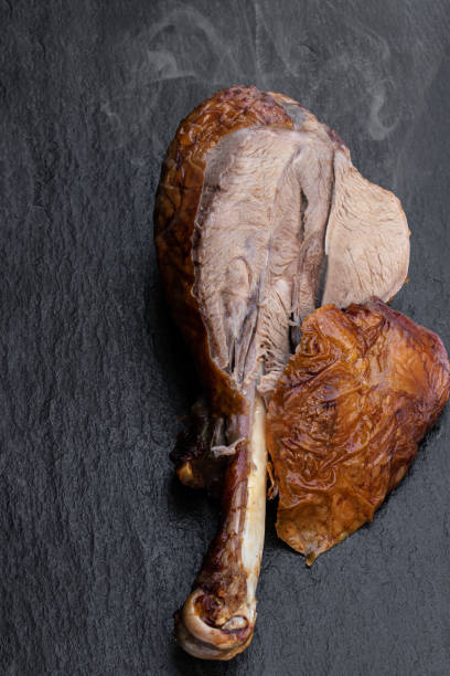 istock Roasted turkey leg on black stone background 1299489299