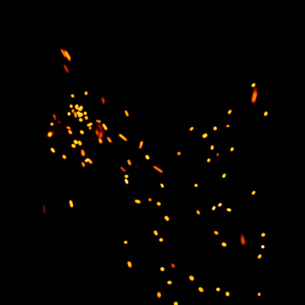 istock blurred bright sparks on black background, yellow hot blurred lights on dark background. 1299490227