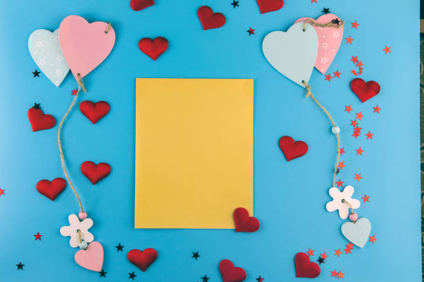 istock Top view of box, hearts and an envelope with free space for text on a pastel blue background. Mother's day concept. Flat lay, top view. Colored hearts tied together. 1299491302