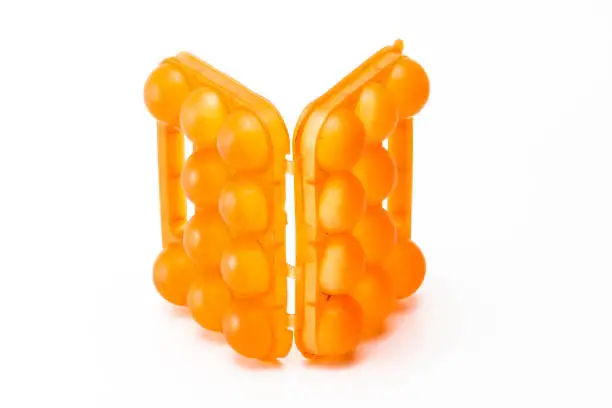 Picture of Open Empty Obsolete Orange Egg Holder. Placed Against White Background.Horizontal Shot