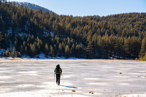 Male travelers hiking on a frozen lake near Antalya Bey Mountains