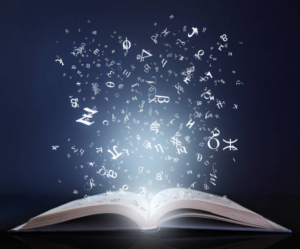 istock Magic book with shiny letters and symbols 1299492752