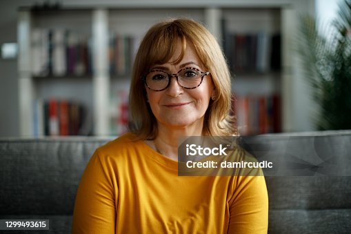 istock Portrait of smiling senior woman at home 1299493615
