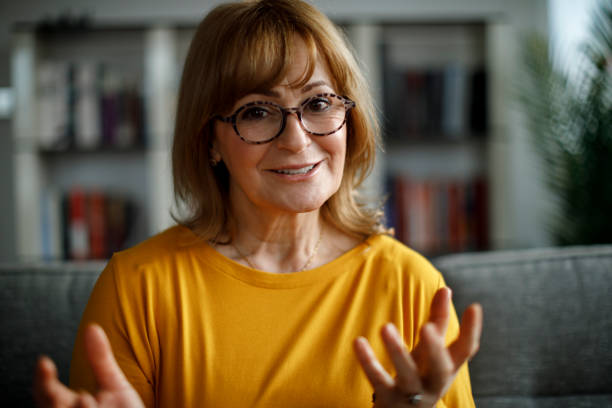 istock Smiling senior woman talking on video call at home 1299493648