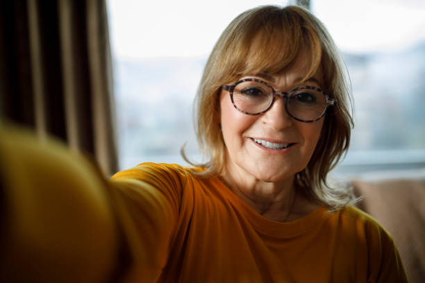 istock Smiling happy senior woman making selfie at home 1299493723