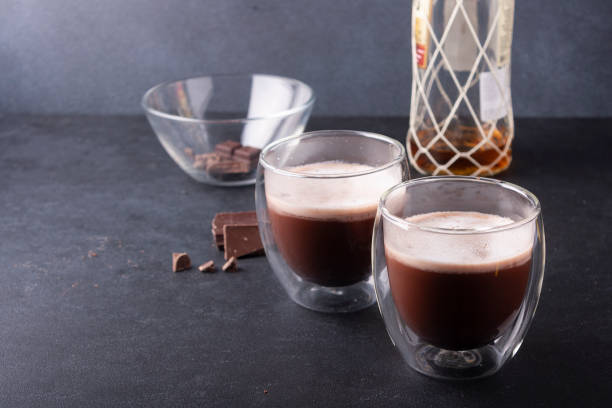 istock Rum cocoa in glasses and a bottle of rum on a blue background. 1299493839