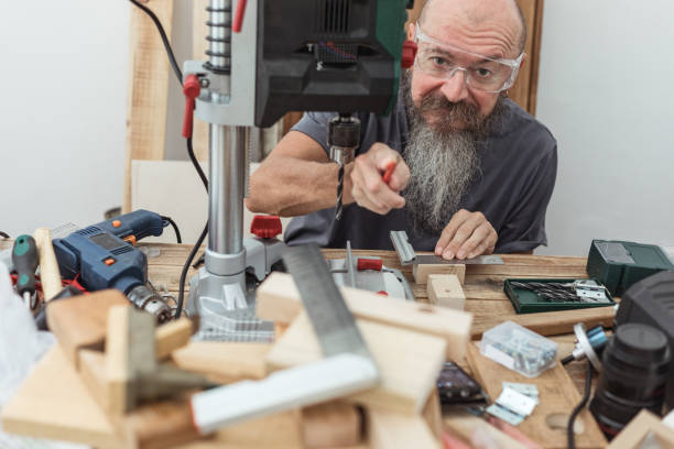 istock Mid age man DIY woodworking at home smiling pointing pencil towards camera 1299494496