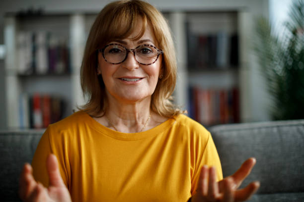istock Smiling senior woman talking on video call at home 1299494557